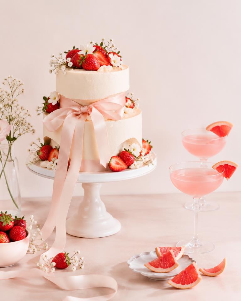tiered strawberry cake with satin ribbon and pink mocktails